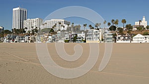 California summertime beach aesthetic, sunny blue sky, sand and many different beachfront weekend houses. Seafront