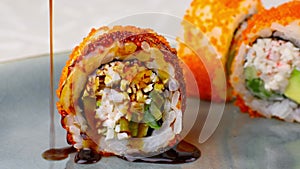 California sushi rolls with crab, avocado, tobiko caviar, close-up 4k footage, pouring sauce over premium California