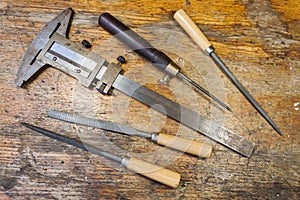 Caliper, files and pricker on a table in a workshop