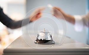 Call Bell Standing On Counter At Hotel, Receptionist Giving Key