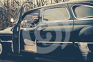 Call boy in vintage auto. Bearded man in car. Retro collection car and auto repair by mechanic driver. Travel and