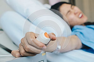 Patient woman trying to pressing emergency button in hospital ward for calling nurse or health care staff.