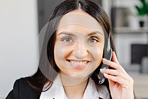 Call center agent with headset working on support hotline in modern office. Video conference