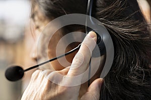 Call center agent talking in headset mic, using remote access tools, closeup