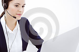 Call center. Beautiful woman sitting and working in headset at customer service office. Business concept