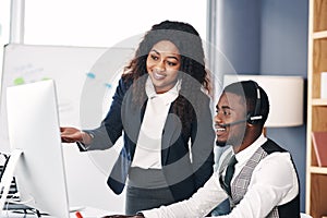 Call center, black people training and with computer at desk in a office with the team coach. Telemarketing or