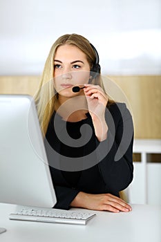 Call center. Blonde business woman sitting in headset at customer service office. Concept of telesales business or home