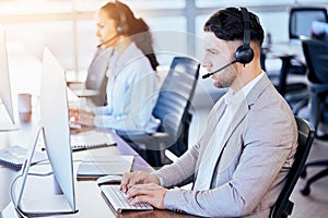 Call center, computer and typing man in office for customer service, technical support and help desk. Telemarketing