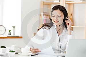 Call Center Concept: Portrait of happy smiling female customer support phone operator at workplace.
