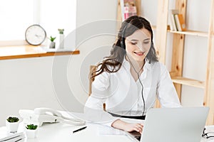 Call Center Concept: Portrait of happy smiling female customer support phone operator at workplace.