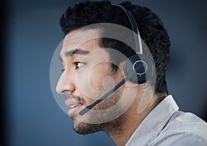 Call center, face and headset with Indian man in telemarketing office for customer support. Consulting, contact us and