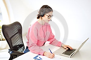 Call center operator businesswoman wearing headset and using laptop while working from home