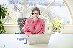 Call center operator businesswoman wearing headset and using laptop while working from home