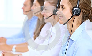 Call center operator in headset while consulting client. Telemarketing or phone sales