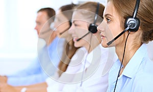 Call center operator in headset while consulting client. Telemarketing or phone sales