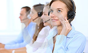 Call center operator in headset while consulting client. Telemarketing or phone sales