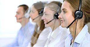 Call center operator in headset while consulting client. Telemarketing or phone sales