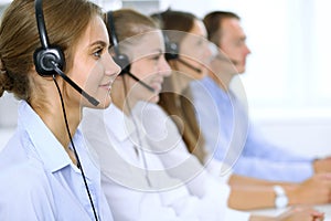 Call center operator in headset while consulting client. Telemarketing or phone sales