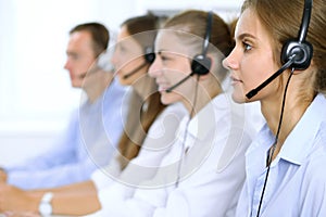 Call center operator in headset while consulting client. Telemarketing or phone sales