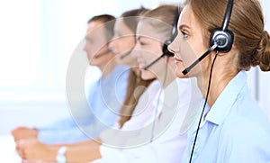 Call center operator in headset while consulting client. Telemarketing or phone sales