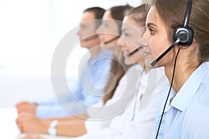 Call center operator in headset while consulting client. Telemarketing or phone sales. Customer service and business