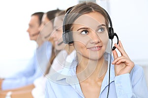 Call center operator in headset while consulting client. Telemarketing or phone sales. Customer service and business