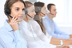 Call center operator in headset while consulting client. Telemarketing or phone sales. Customer service and business