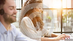 Call center operator at work. Male manager wearing headset and using laptop