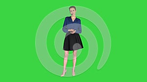 Call center woman with headset posing to camera on a green screen, chroma key.