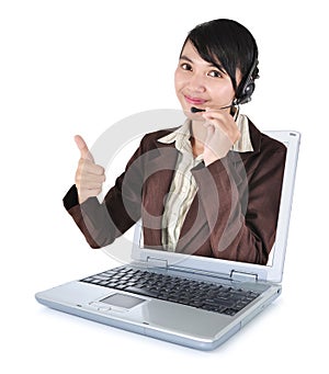 Call center woman with headset showing thumbs up with laptop