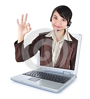 Call center woman with headset smiling out of the laptop