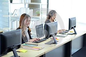 Call center worker accompanied by her team. Smiling customer support operator at work. Professional operator concept