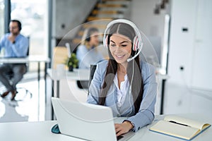 Call center worker having conversation with customer during online chat support at office