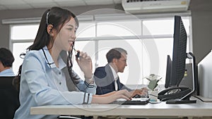 Call center young employee working with headset, Smiling customer support operator team at work surrounded