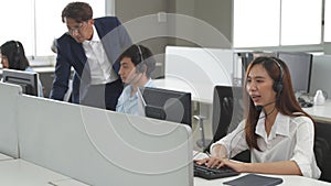 Call center young employee working with headset, Smiling customer support operator team at work surrounded