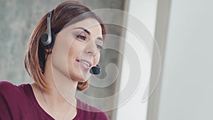 Call centre agent working in bright office talking with the headset