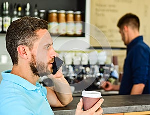 Call friend to have drink together. Guy busy speak phone while relax coffee break. Ready to hear you. Man holds cup of