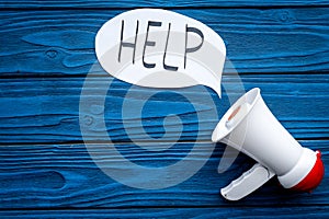 Call for help concept. Megaphone near cloud with word help on blue wooden background top view space for text