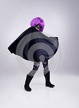 They call her the invisible purple. A studio shot of a confident little girl playing dress-up.