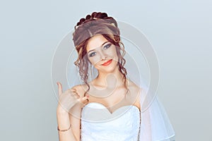 Call me. Beautiful bride, woman girl showing call me hand gesture on my mobile looking at you camera. Isolated light blue