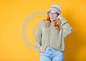 Call me. Woman gesturing at speaking on phone while looking to camera, isolated on yellow background. Woman on phone