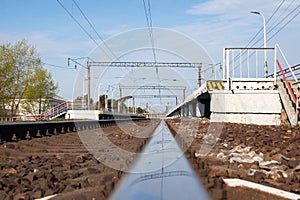 The call to travel comes from the railway . The sky is reflected in its steel rails .