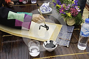 Calligrapher painting words on paper. Calligraphy is a traditional culture in Eastern lunar new year. Focus on the text