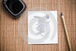 calligraphy brush with white paper and and inkstone on bamboo mat. picture for add text or greeting card chinese new year.