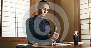 Calligraphy, ink and traditional Japanese man with paper for letters, notes and text for documents or script. Creative