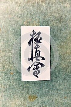 Calligraphy - Kyokushinkai karate symbol on linen background.  `Kyokushin` is Japanese for `the ultimate truth`. Top view. Copy sp photo