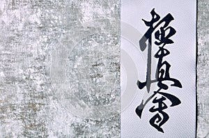 Calligraphy - Kyokushinkai karate symbol on wooden background.  `Kyokushin` is a style of stand-up, full contact karatei and is Ja photo