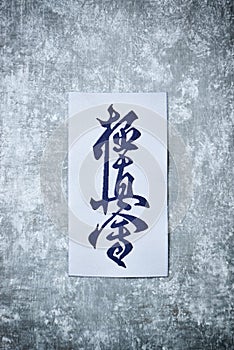 Calligraphy - Kyokushinkai karate symbol on wooden background. photo