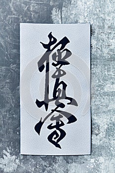 Calligraphy - Kyokushinkai karate symbol on wooden background. photo