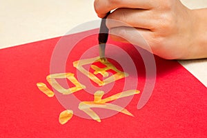 Calligraphy Master writing Golden character Fu means Blessing, Fortune, Luck. Traditional decoration Chinese New Year